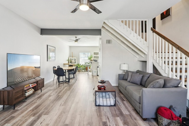 dining room with light hardwood / wood-style floors, beam ceiling, and ceiling fan