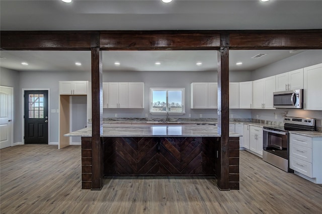 kitchen featuring light stone counters, white cabinets, and appliances with stainless steel finishes