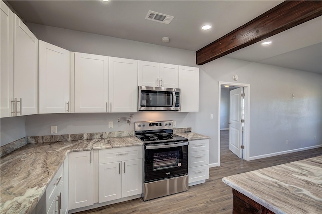 kitchen with white cabinets, light stone countertops, recessed lighting, beam ceiling, and appliances with stainless steel finishes