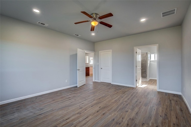 unfurnished bedroom featuring wood-type flooring, connected bathroom, and ceiling fan