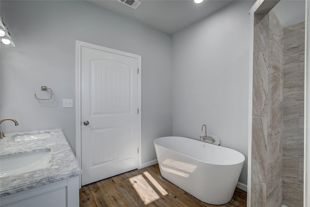 bathroom featuring a bath, vanity, and hardwood / wood-style flooring