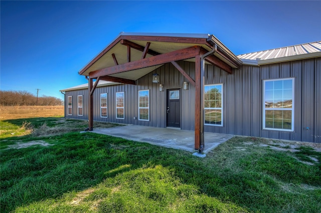 rear view of property featuring a yard and a patio area