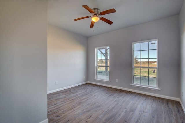 spare room featuring light wood-type flooring, a wealth of natural light, and ceiling fan