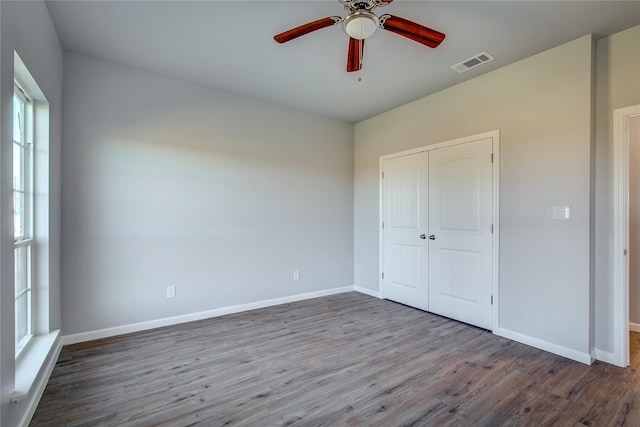 unfurnished bedroom with hardwood / wood-style floors, a closet, and ceiling fan