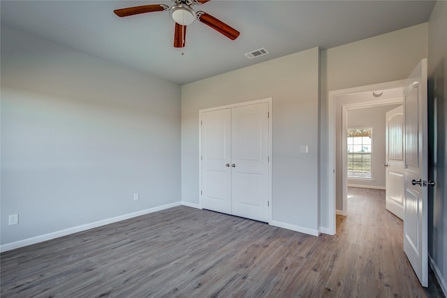 unfurnished bedroom with a closet, light hardwood / wood-style flooring, and ceiling fan