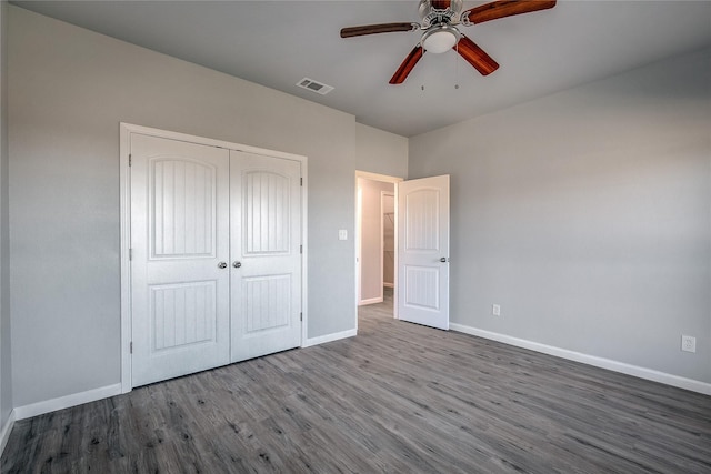 unfurnished bedroom with ceiling fan, a closet, and wood-type flooring