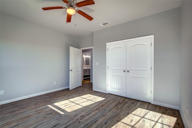 unfurnished bedroom featuring ceiling fan, dark wood-type flooring, and a closet