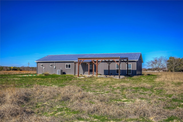 rear view of house with an outbuilding, central AC, an outdoor structure, and metal roof