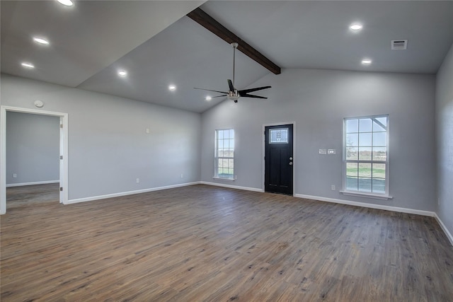 unfurnished living room with beam ceiling, a wealth of natural light, ceiling fan, and dark wood-type flooring