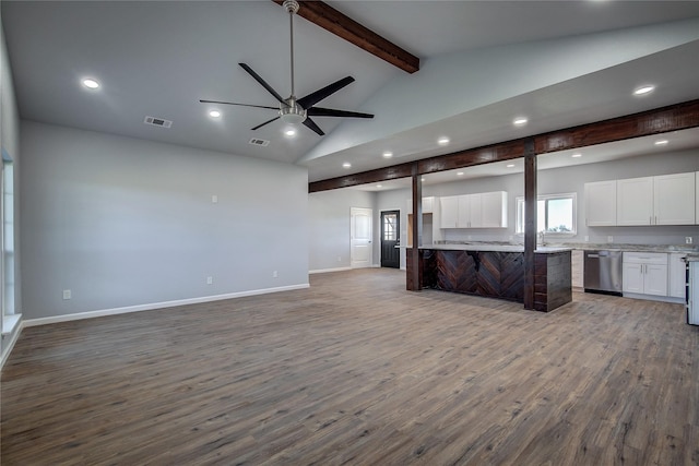 kitchen featuring white cabinetry, dishwasher, ceiling fan, vaulted ceiling with beams, and hardwood / wood-style floors