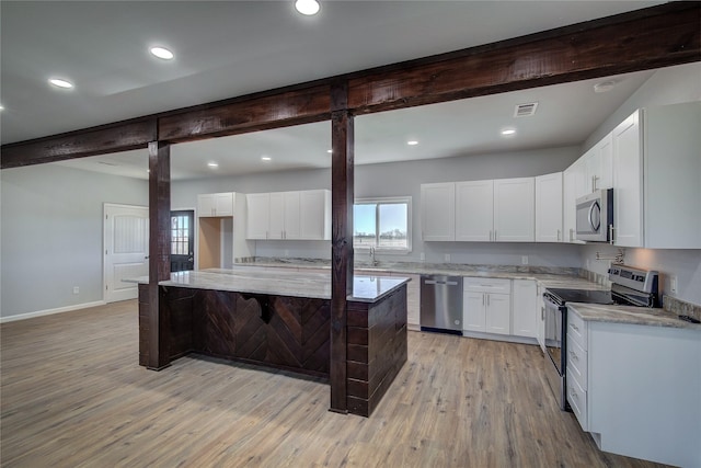 kitchen with a center island, sink, light hardwood / wood-style floors, white cabinetry, and stainless steel appliances