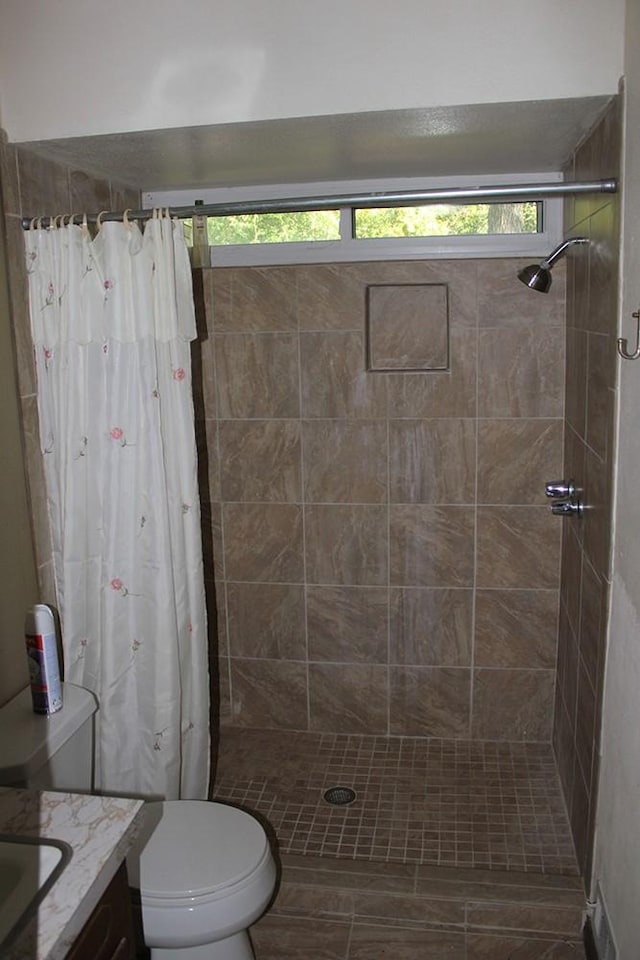 bathroom featuring curtained shower, vanity, and toilet