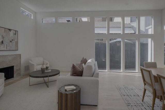 living room featuring a high end fireplace and hardwood / wood-style flooring