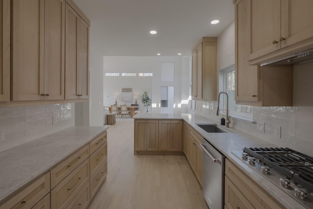 kitchen featuring sink, kitchen peninsula, light hardwood / wood-style floors, light brown cabinetry, and appliances with stainless steel finishes