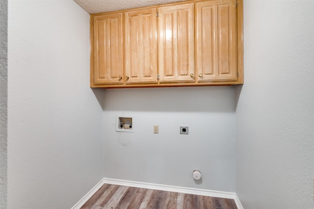 clothes washing area featuring cabinets, washer hookup, hookup for an electric dryer, a textured ceiling, and wood-type flooring