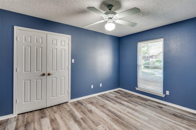 unfurnished room with light wood-type flooring, a textured ceiling, and ceiling fan