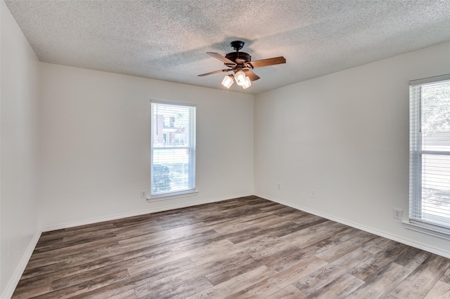 empty room featuring ceiling fan, wood-type flooring, and a textured ceiling