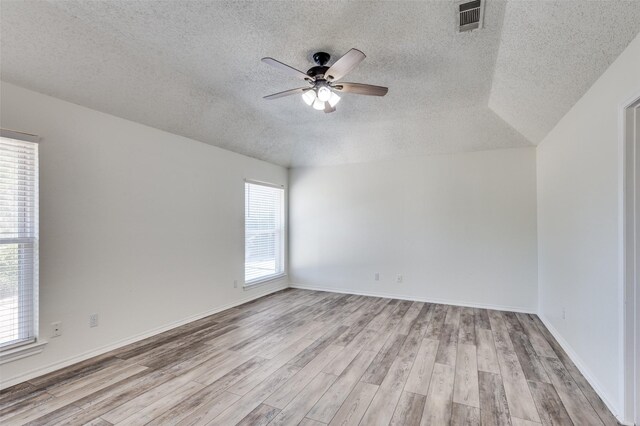 empty room with ceiling fan, a healthy amount of sunlight, and light hardwood / wood-style floors