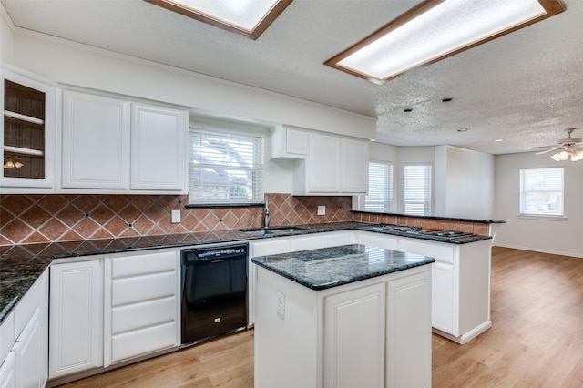 kitchen featuring white cabinetry, sink, a center island, and black dishwasher