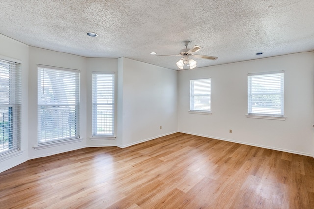 unfurnished room featuring ceiling fan, light hardwood / wood-style flooring, and a textured ceiling