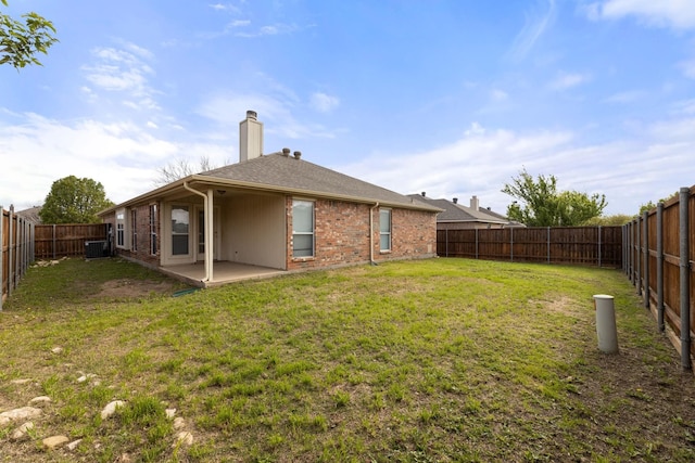 rear view of property with a patio, central air condition unit, and a lawn