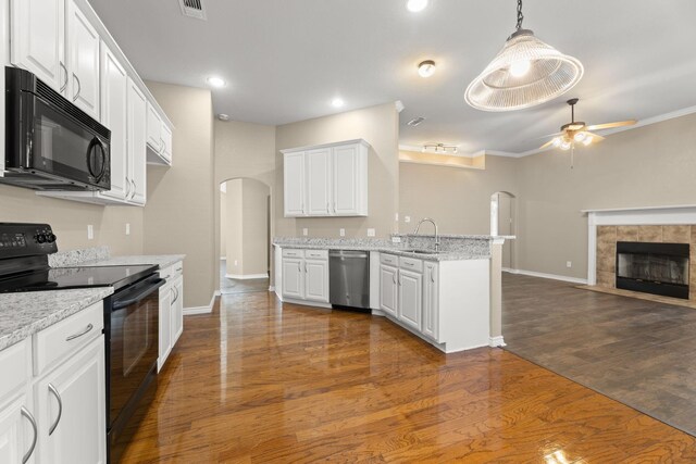 kitchen featuring ceiling fan, dark wood-type flooring, black appliances, white cabinets, and hanging light fixtures