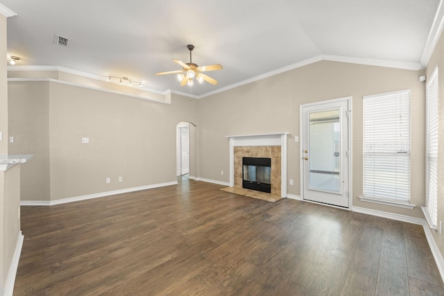 unfurnished living room with ceiling fan, dark hardwood / wood-style floors, crown molding, vaulted ceiling, and a fireplace