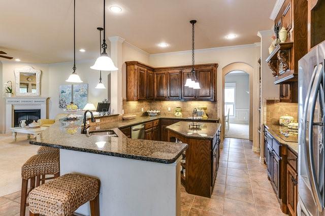 kitchen with appliances with stainless steel finishes, kitchen peninsula, sink, and hanging light fixtures