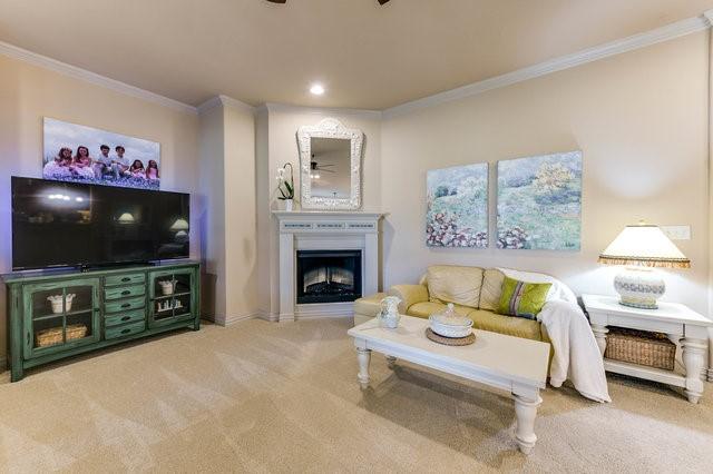 carpeted living room featuring crown molding