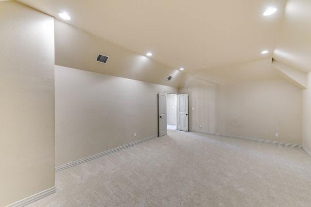 additional living space with vaulted ceiling and light carpet