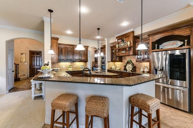 kitchen featuring decorative light fixtures, a breakfast bar area, stainless steel appliances, and kitchen peninsula