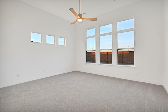 empty room featuring vaulted ceiling, ceiling fan, and carpet floors