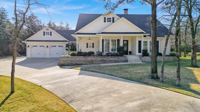 view of front of house with a porch, a front yard, and a garage