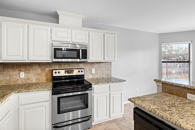 kitchen with light stone countertops, appliances with stainless steel finishes, backsplash, white cabinets, and light tile patterned flooring