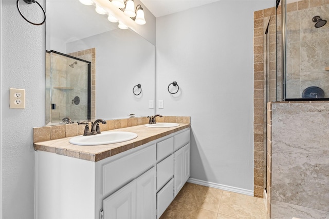 bathroom with tile patterned flooring, vanity, and walk in shower