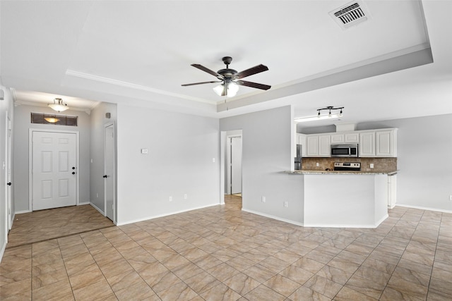 unfurnished living room with a raised ceiling, ceiling fan, and ornamental molding