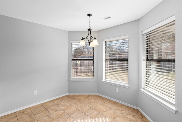 spare room with light tile patterned floors and an inviting chandelier