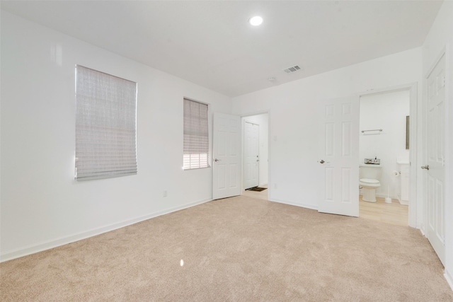 unfurnished bedroom with light carpet and ensuite bath