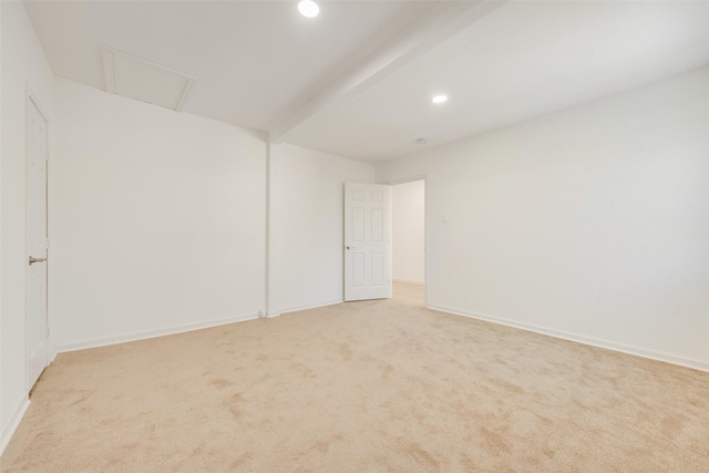 carpeted empty room with beamed ceiling