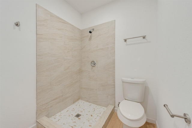 bathroom with toilet and tiled shower