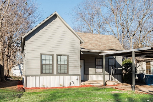 rear view of house with a lawn and a carport