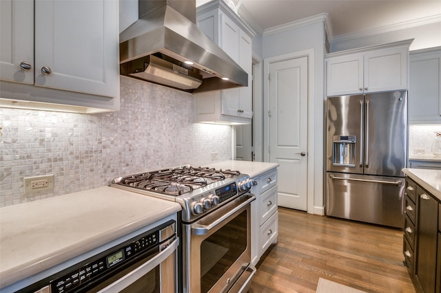 kitchen with crown molding, light hardwood / wood-style flooring, appliances with stainless steel finishes, backsplash, and range hood