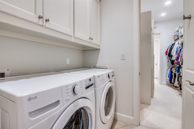 clothes washing area with cabinets and independent washer and dryer