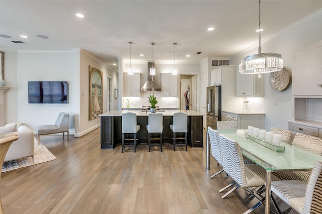 dining area featuring ornamental molding and light hardwood / wood-style flooring