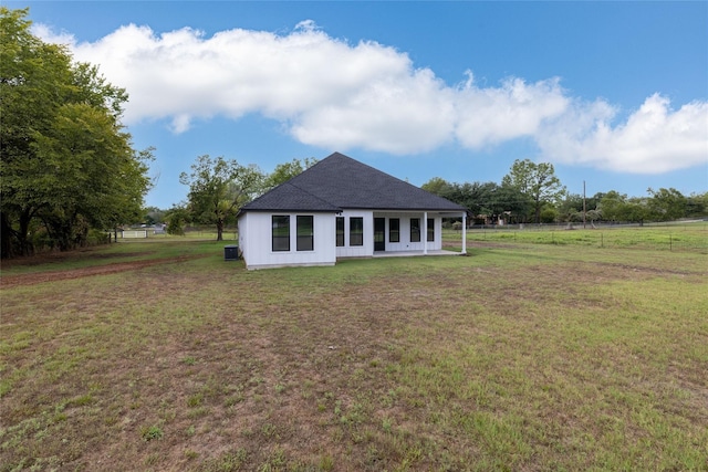 back of property featuring a yard and a rural view