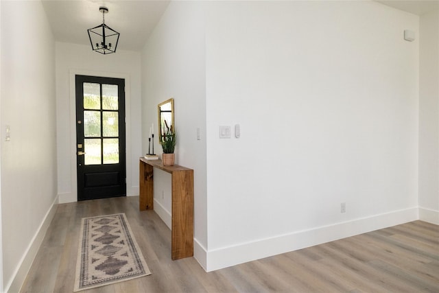 entrance foyer with light hardwood / wood-style floors and an inviting chandelier