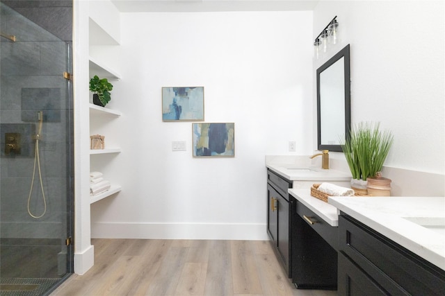 bathroom with hardwood / wood-style flooring, vanity, and a shower with shower door