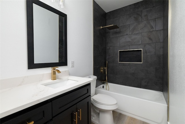 full bathroom with hardwood / wood-style floors, tiled shower / bath combo, toilet, and vanity