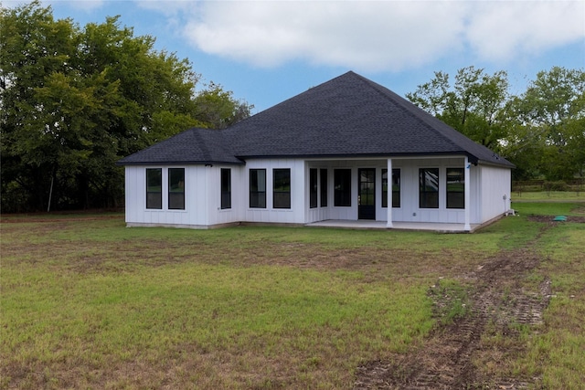 rear view of property with a yard