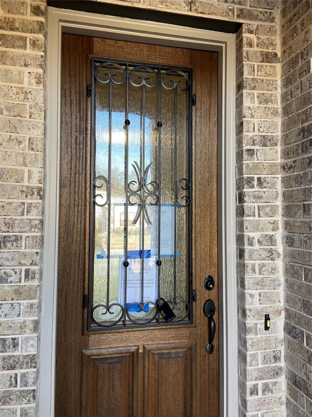 doorway to property featuring brick siding